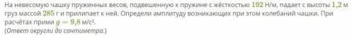 На невесомую чашку пружинных весов, подвешенную к пружине с жёсткостью 192 Н/м, падает с высоты 1,2